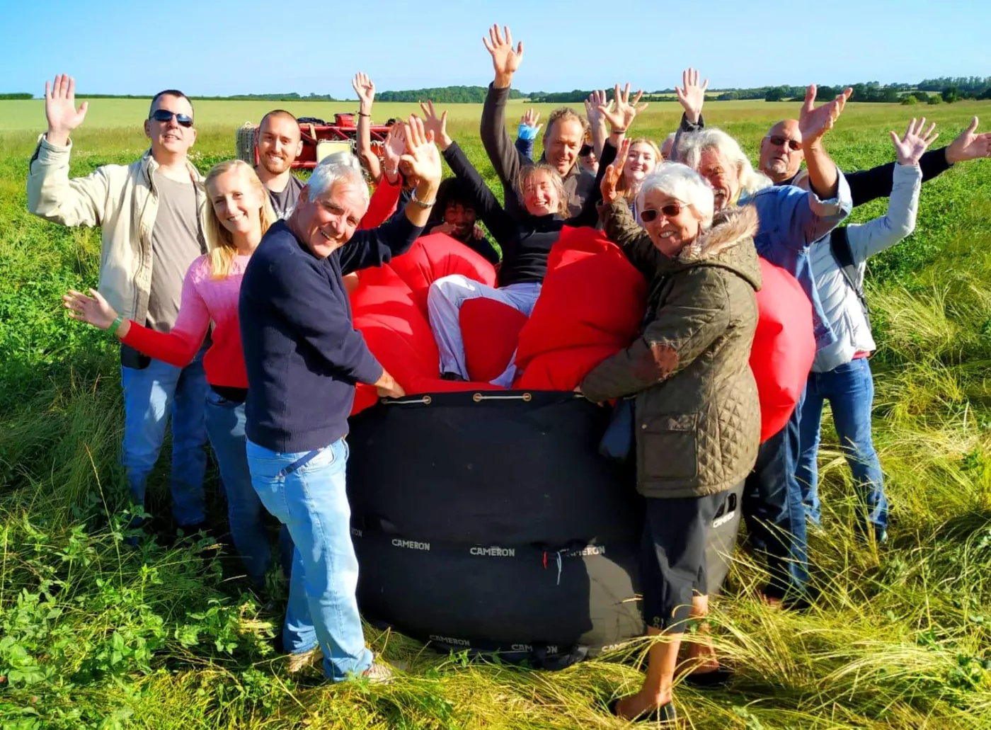Passengers helping pack away a hot air balloon after landing
